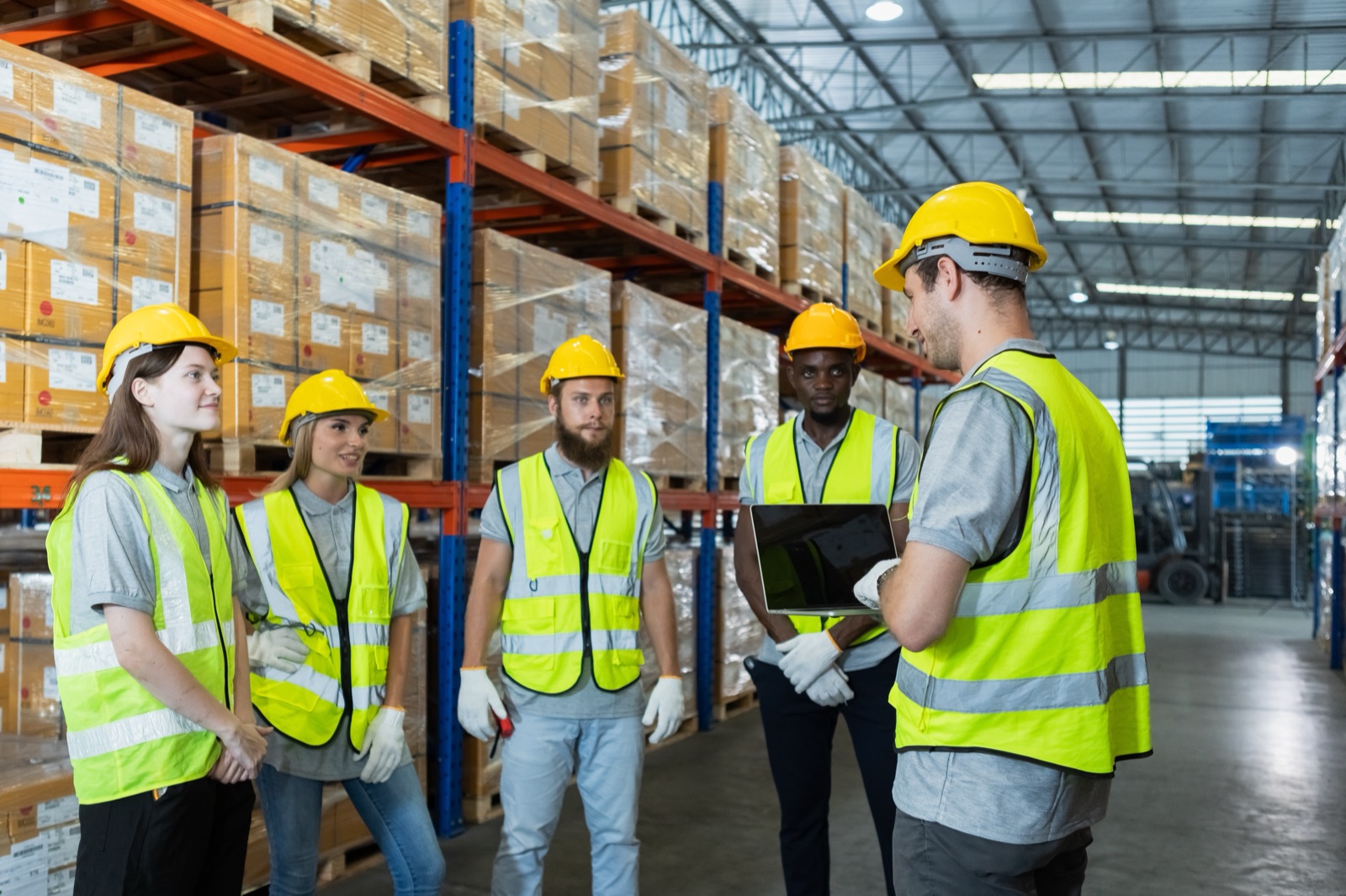 Equipo de trabajadores con cascos y chalecos reflectantes en una capacitación
